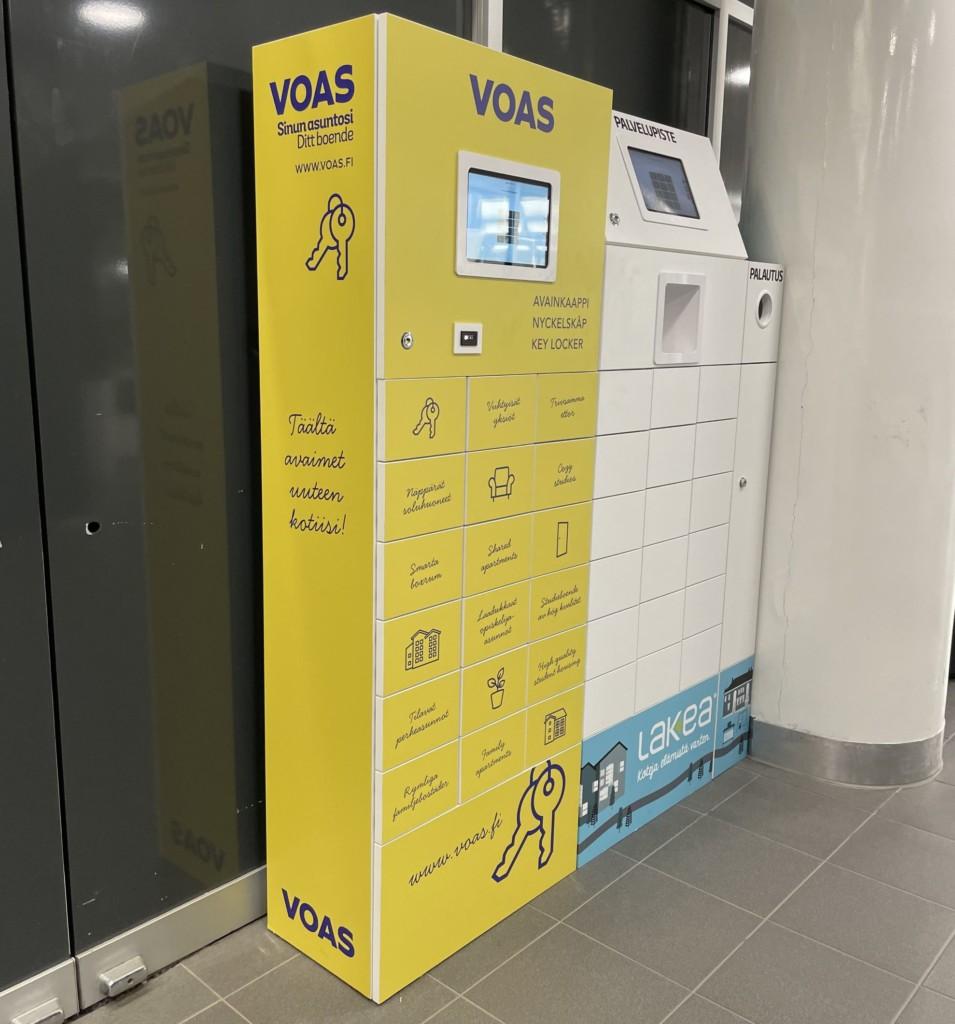 VOAS keltainen avainkaappi, jossa on monta lokeroa ja näyttö jonka kautta automaattia hallitaan. 